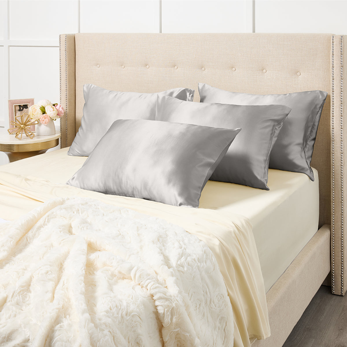 Bed dressed with silver silk pillowcases