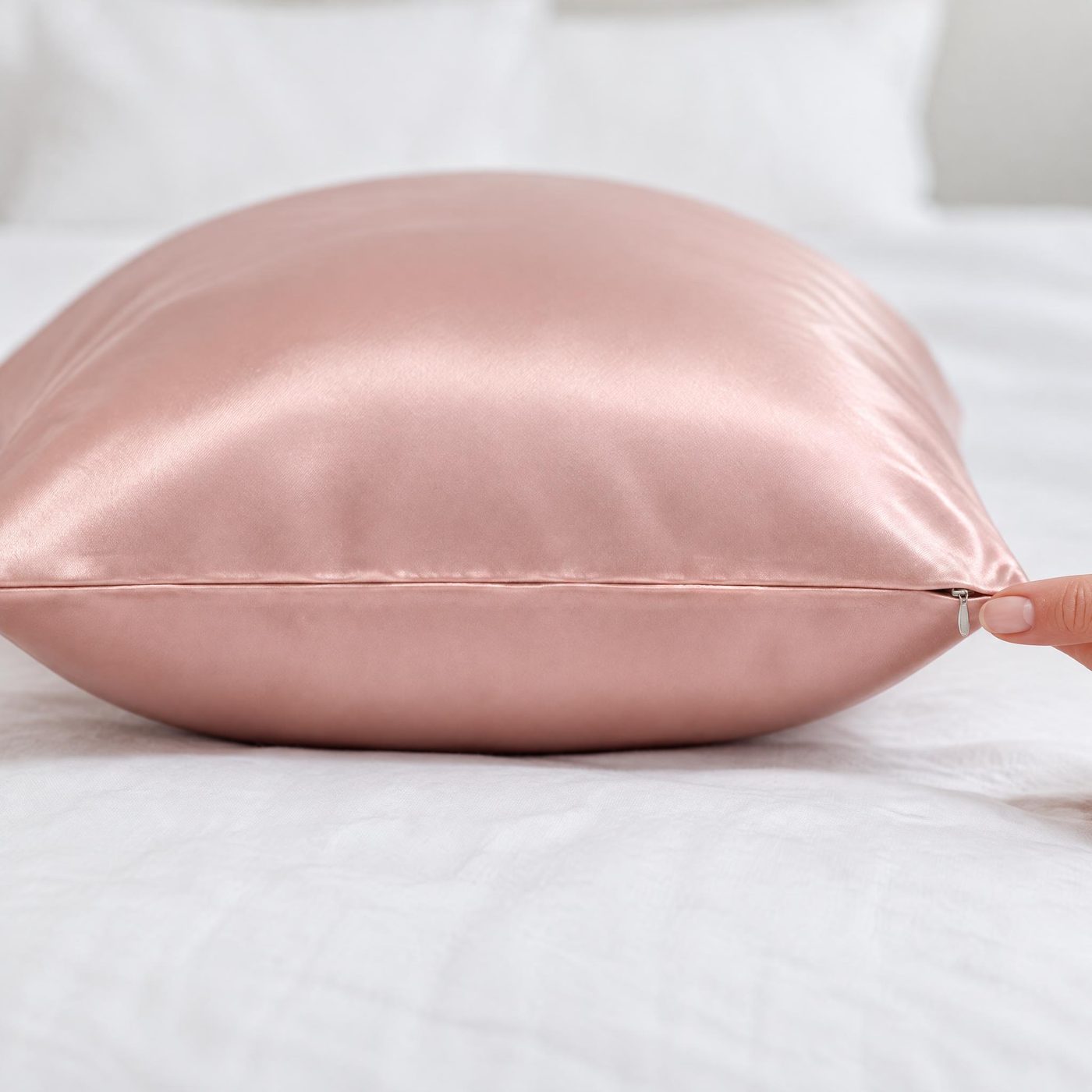 End of a pink silk pillowcase with the zipper hidden along the seam